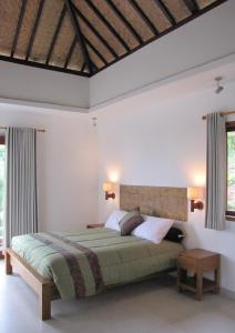 a bedroom with a bed and two windows at Terrasse du Lac Munduk in Munduk