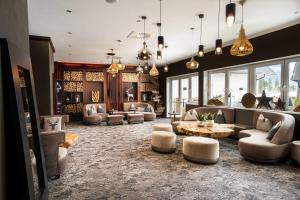 a living room with couches and tables and windows at KUHOTEL Steinplatte, Trademark Collection by Wyndham in Waidring