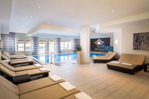 a living room with couches and a pool at KUHOTEL Steinplatte, Trademark Collection by Wyndham in Waidring