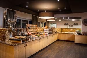 a restaurant with a counter with food on it at KUHOTEL Steinplatte, Trademark Collection by Wyndham in Waidring