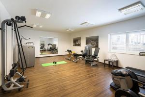 a gym with treadmills and exercise equipment in a room at KUHOTEL Steinplatte, Trademark Collection by Wyndham in Waidring +40 photos