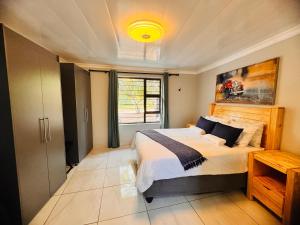 a bedroom with a large bed and a window at Unogwaja Rest in Marloth Park +20 photos
