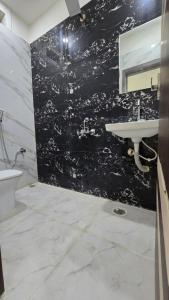 a bathroom with a sink and a black wall at SHRI DIVYAM Hotel & Restaurant in Bhopal