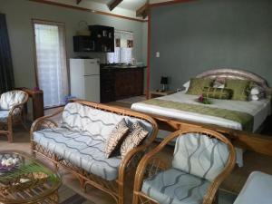 a living room with a couch and a bed at Sunset Palms Rarotonga in Rarotonga