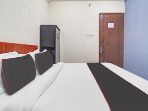 a bedroom with a bed with two chairs and a door at HOTEL PNR SUITES KUKATPALLY in Hyderabad