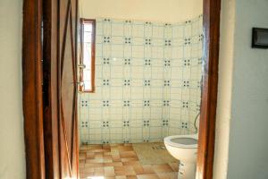 a bathroom with a toilet and a tiled wall at Appartement City Center in Ouarzazate