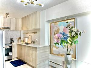a kitchen with a vase of flowers on a glass table at 17th Ave Cozy Place in DT, short walk to Calgary Stampede in Calgary