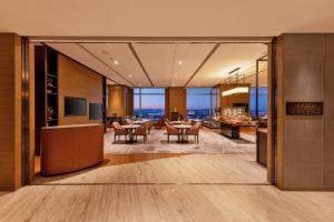 a lobby with tables and chairs in a building at Shangri-La Songbei, Harbin in Harbin