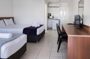 Habitación de hotel con 2 camas y escritorio con ordenador en Sunshine Beach Resort en Gold Coast