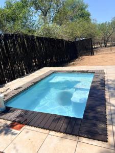 a small blue swimming pool with a wooden fence at Unogwaja Rest in Marloth Park