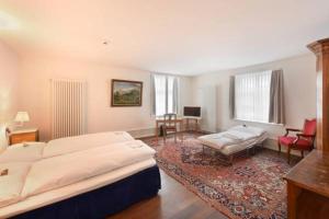 a bedroom with a large bed and a living room at Hotel im Schlosspark in Basel