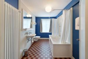 a bathroom with a white tub and a toilet and a sink at Hotel im Schlosspark in Basel