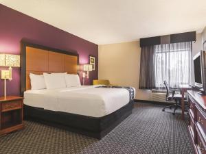 a hotel room with a large bed and a desk at Wingate by Wyndham Brunswick GA I-95 in Brunswick