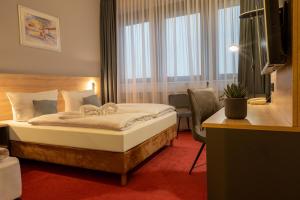 a hotel room with a bed and a desk and window at Best Western Comfort Business Hotel Düsseldorf-Neuss in Neuss +125 photos