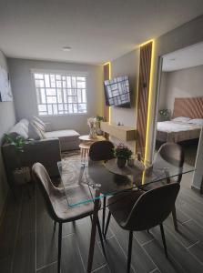 a living room with a glass table and chairs at Depto Moderno Cerca de AIFA estacionamiento wifi in Santa Cruz Tecamac