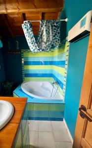 a bathroom with a tub with blue and yellow at Comme à la maison à la montagne in Briançon +45 photos