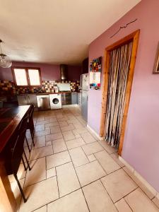 a kitchen with a refrigerator and a tile floor at Comme à la maison à la montagne in Briançon