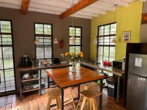 a kitchen with a wooden table with flowers on it at Porcupine House in Magaliesburg