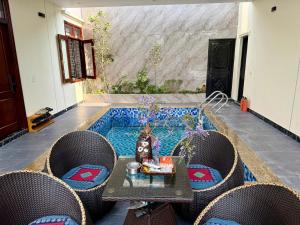 a patio with a table and chairs and a pool at De' Mon Villa in Làng Tong Tchoung