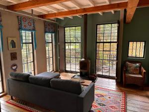 a living room with a couch and a fireplace at Porcupine House in Magaliesburg +18 photos