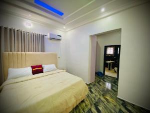 a bedroom with a bed with a red pillow on it at Gustavó Premium Apartment in Benin City