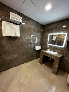 a bathroom with a sink and a mirror at Rasoda Hotel&Restaurant in Tashkent