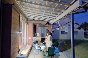 a woman standing under a pergola on a patio at 古民家宿Tabi湊 in Hitachinaka +37 photos