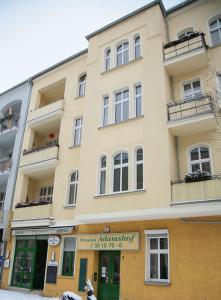 un gran edificio amarillo con ventanas y balcones en Hotel-Pension Adamshof, en Berlín