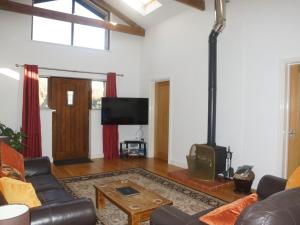 a living room with a couch and a wood stove at Dilly Dally Barn in Holsworthy