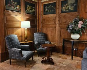 a room with two chairs and a table and a vase of flowers at Hotel de La Font Peralada in Peralada +26 photos