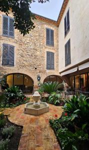 a stone building with a fountain in front of it at Hotel de La Font Peralada in Peralada