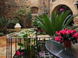 a patio with a table and some plants and flowers at Hotel de La Font Peralada in Peralada