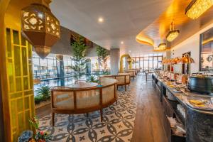 a restaurant with tables and chairs and a bar at Azana Boutique Hotel Solo in Purwosari
