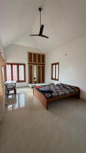 a large bedroom with a bed and a ceiling fan at Serenity Springs in Mysore