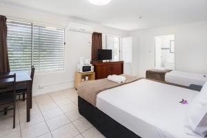 a hotel room with a bed and a desk and a television at Sunshine Beach Resort in Gold Coast