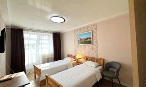 a hotel room with two beds and a window at Khongor Guest house & Tours in Ulaanbaatar