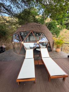 a gazebo with white benches on a deck at Domo Alto del Monte in Alto del Monte