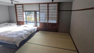 a bedroom with a bed and a window at 川まで徒歩1分川沿いにある一軒宿あせみ in Nakajima