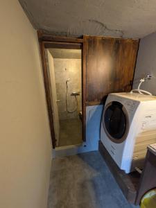 a washer and dryer sitting in a room at 川まで徒歩1分川沿いにある一軒宿あせみ in Nakajima