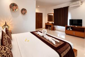 a bedroom with a bed with two white towels at Puri Anyar Ubud by Puri Signatures in Ubud