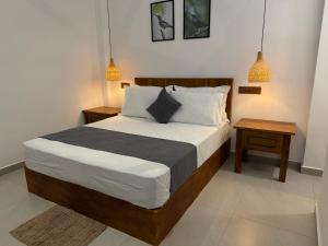a bedroom with a large bed with two night stands at Nest & Rest in Sri Jayewardenepura Kotte