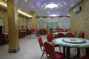a dining room with tables and red chairs at Takhmao Good Health Hotel in Ta Khmau
