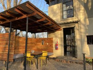 a patio with a table and chairs under a pergola at Porcupine House in Magaliesburg