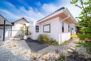a white house with a driveway at Mango Breeze Villa in Ban Nong Chaeng