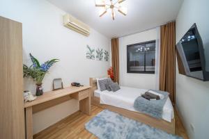 a small bedroom with a bed and a television at Mango Breeze Villa in Ban Nong Chaeng