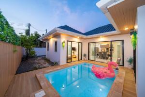 a swimming pool with a pink swan in a house at Mango Breeze Villa in Ban Nong Chaeng