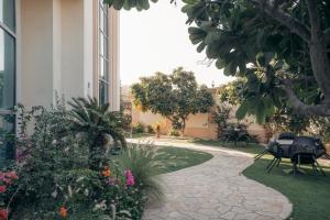 a garden with flowers and tables and a building at Full Moon Guesthouse in Dubai
