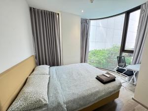 a bedroom with a bed and a large window at Fynn Bangkok Asoke Condo in Bangkok