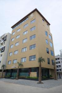 a large building with palm trees in front of it at Hotel Prowell Apex - Kondapur in Hyderabad