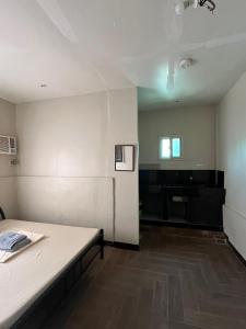 an empty room with a bed and a piano at Little John's Town Inn in Coron
